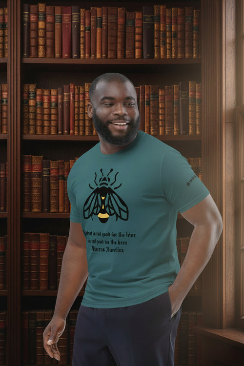 Man wearing a teal t-shirt with Marcus Aurelius quote and a bee design in a study setting